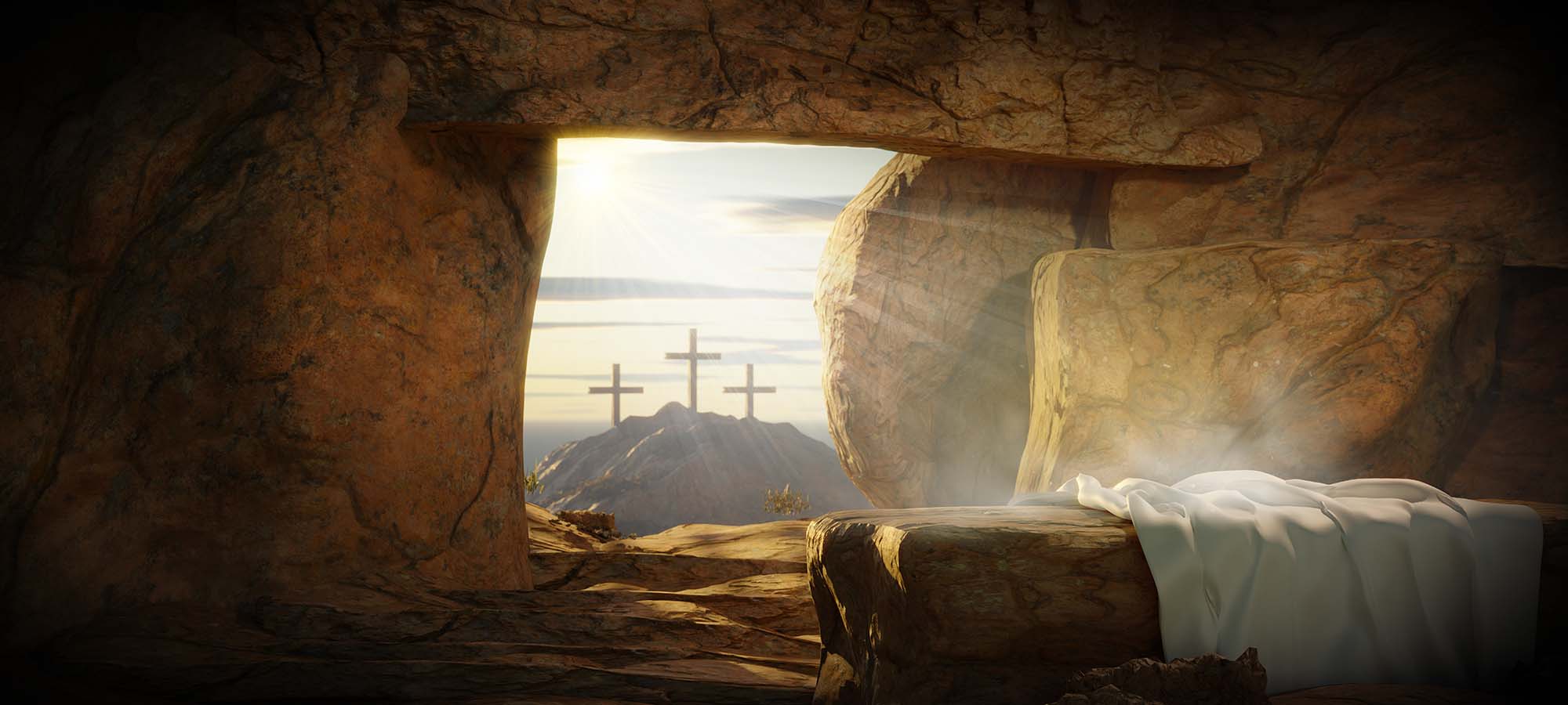 An image of the empty tomb with three crosses on a hill in the distance.